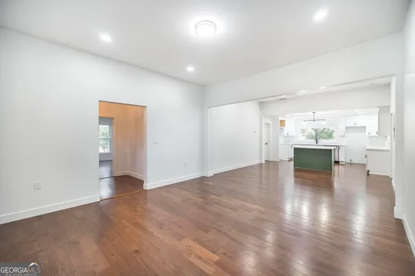 a kitchen with a sink stove cabinets and wooden floor