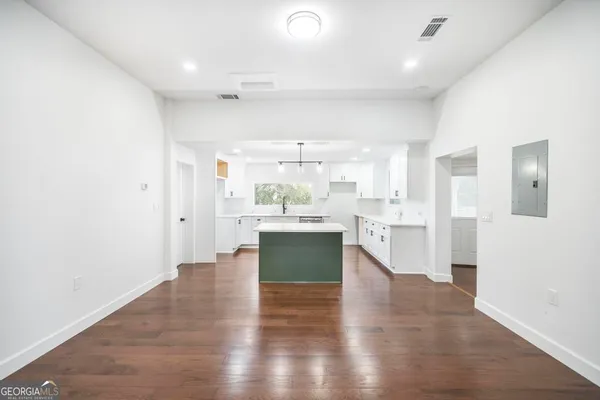 a kitchen with a sink cabinets and wooden floor