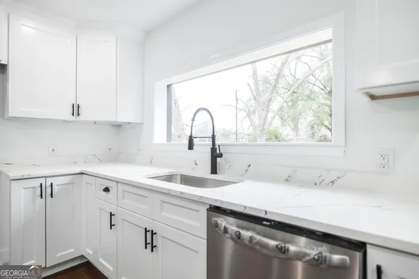 a kitchen with a sink and white cabinets