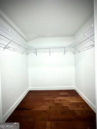 an empty room with wooden floor fireplace and windows