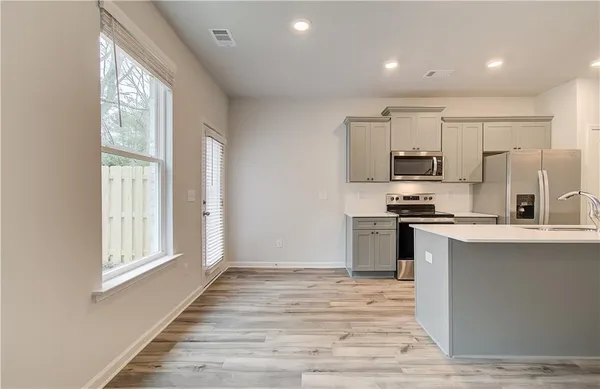 a kitchen with stainless steel appliances a refrigerator and a stove top oven