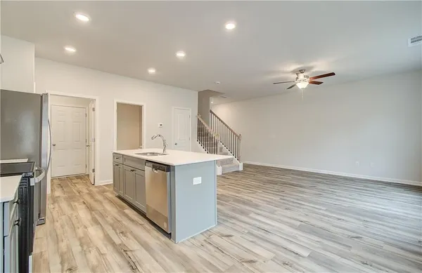 a kitchen with a sink cabinets and wooden floor