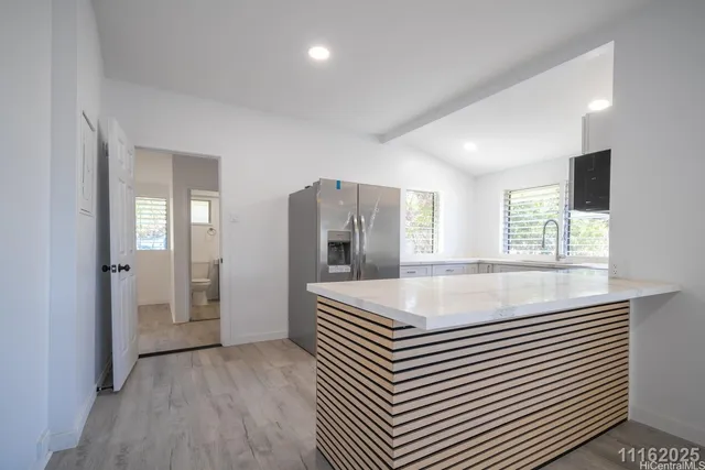 a kitchen with stainless steel appliances white cabinets and a stove top oven