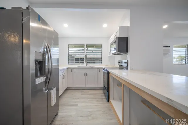 a view of an empty room with wooden floor and closet