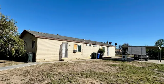a view of a house with backyard and sitting area