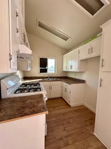a white kitchen with sink and white stove