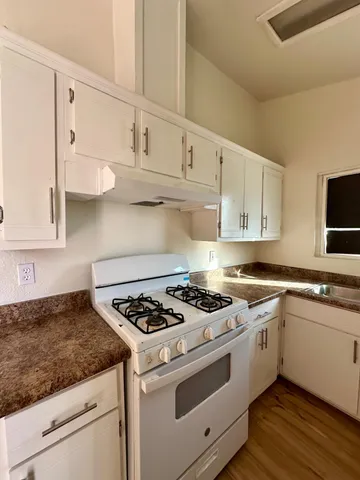 a kitchen with white cabinets and white appliances