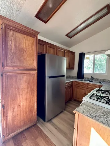 a kitchen with stainless steel appliances granite countertop a refrigerator and a stove