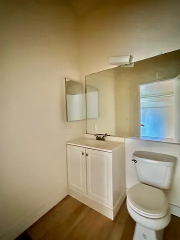 a bathroom with a toilet a sink and mirror