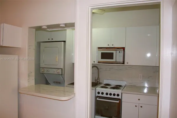 a kitchen with granite countertop a stove and a microwave