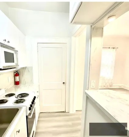a view of a hallway with wooden floor and entryway