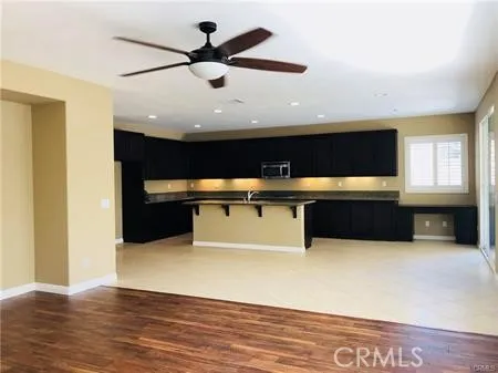 a kitchen with kitchen island stainless steel appliances a sink and wooden floor