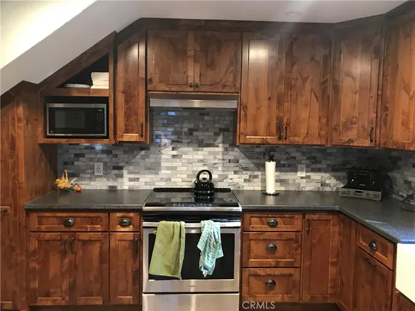 a kitchen with stainless steel appliances granite countertop a stove a sink and a microwave