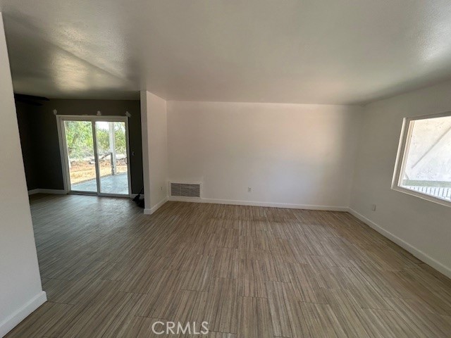 17260 Pfeifer Way Perris, CA 92570 - Photo 10 of 34 an empty room with wooden floor and windows