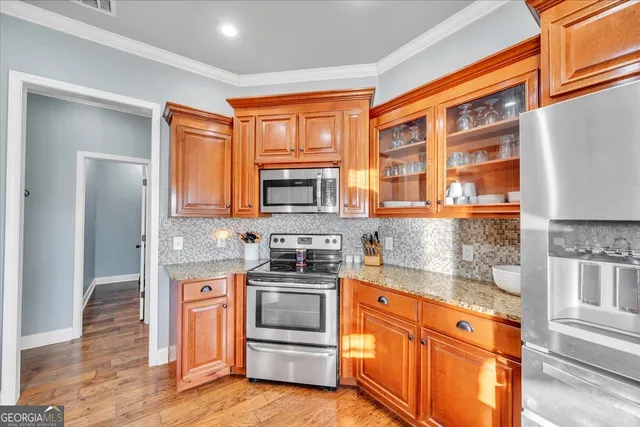 a kitchen with stainless steel appliances granite countertop a stove a sink and a refrigerator