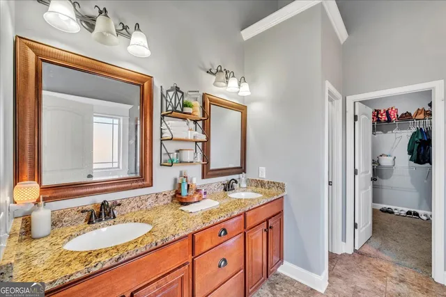 a bathroom with a granite countertop sink double vanity and a mirror