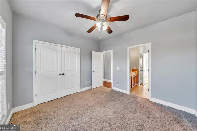 a view of an empty room and chandelier fan