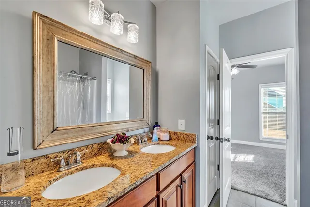 a bathroom with a granite countertop sink a mirror and a shower