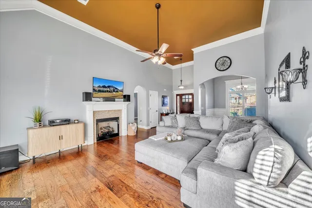 a living room with furniture a fireplace and a chandelier