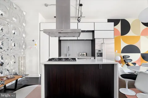 a kitchen with a sink a stove and a wooden floor