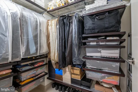 a view of walk in closet with clothes and shoes