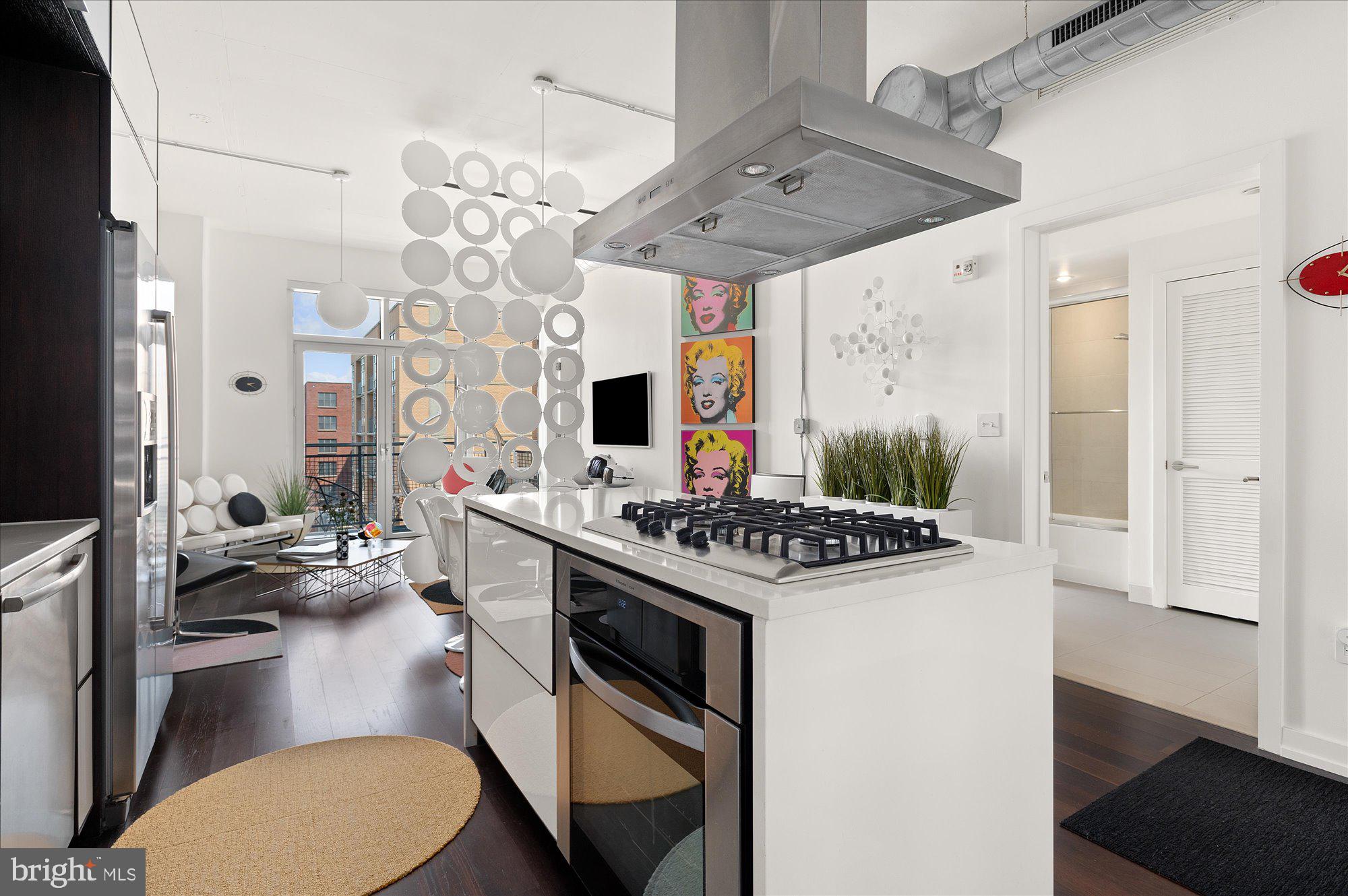 1515 15th Street Northwest, Unit 602 Washington, DC 20005 - Photo 3 of 30 a kitchen with stainless steel appliances a stove a sink dishwasher and white cabinets with wooden floor