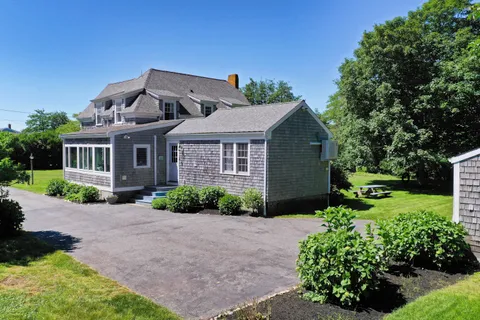 an aerial view of a house with a garden and lake view