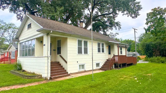 a view of a house with a yard and sitting area