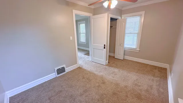 an empty room with fan and entrance