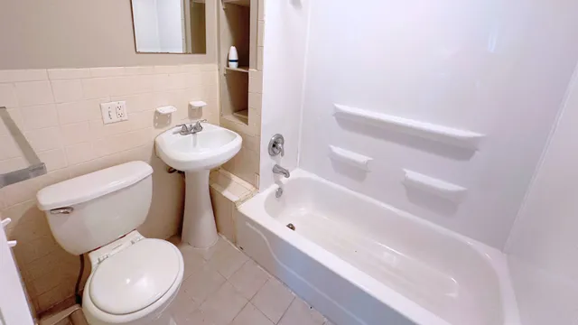 a white toilet sitting next to a bathroom sink