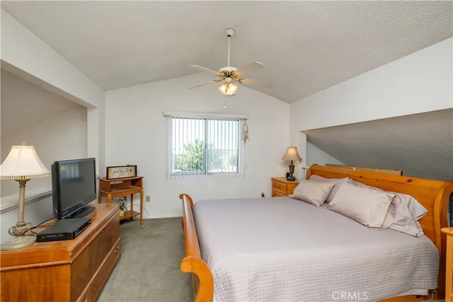 a bedroom with furniture and a chandelier fan