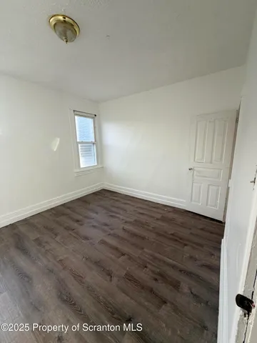 a view of a hallway to a livingroom with furniture and windows