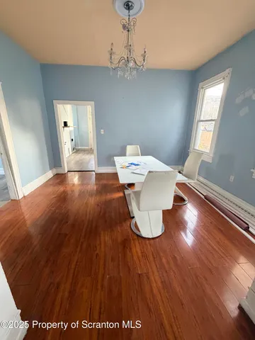 a view of a dining room with furniture wooden floor and chandelier
