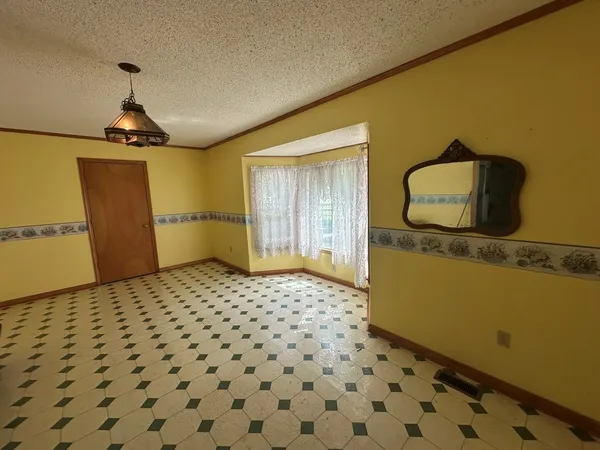 an empty room with wooden floor fireplace and windows