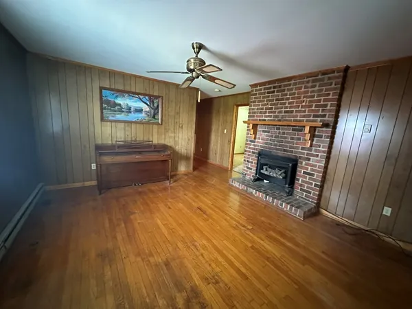 an empty room with a chandelier fan and windows