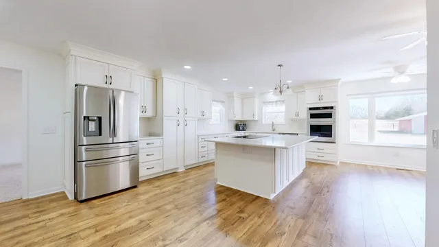 an empty room with windows and fan