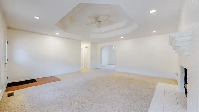 an empty room with a ceiling fan and a window