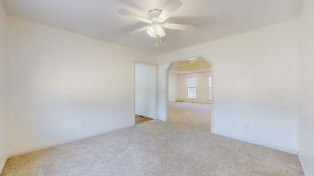 a large kitchen with stainless steel appliances a large counter top a stove and a refrigerator with white cabinets