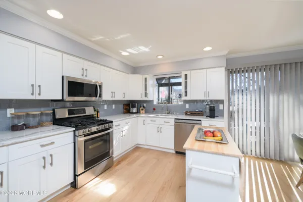 a kitchen with granite countertop stainless steel appliances and white cabinets
