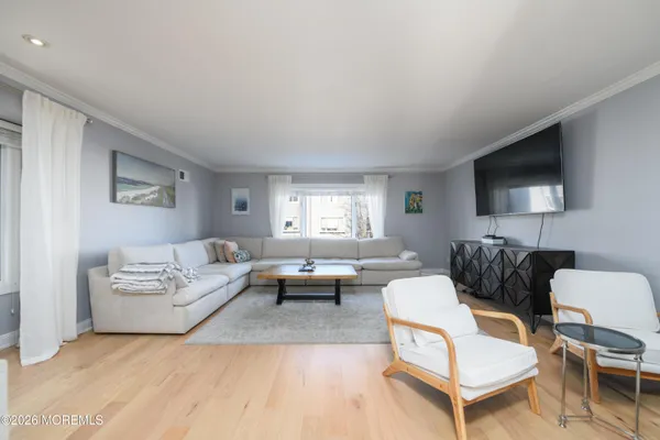a living room with furniture a flat screen tv and a window