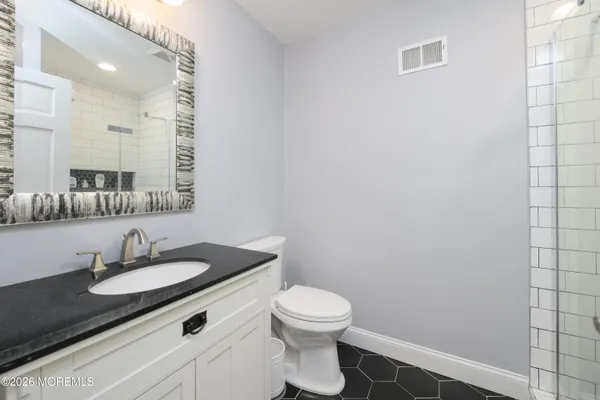 a bathroom with a sink toilet and a mirror