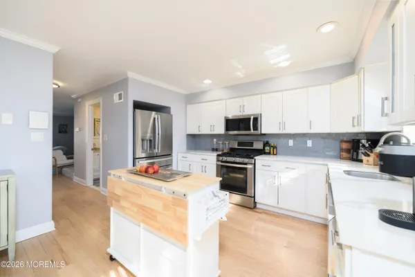 a kitchen with stainless steel appliances kitchen island granite countertop a refrigerator stove microwave and sink