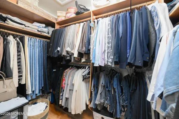 a view of walk in closet with clothes and shoes