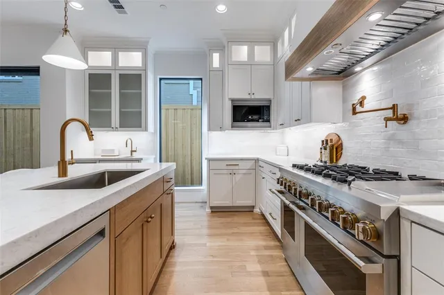 a kitchen with stainless steel appliances a sink stove and cabinets