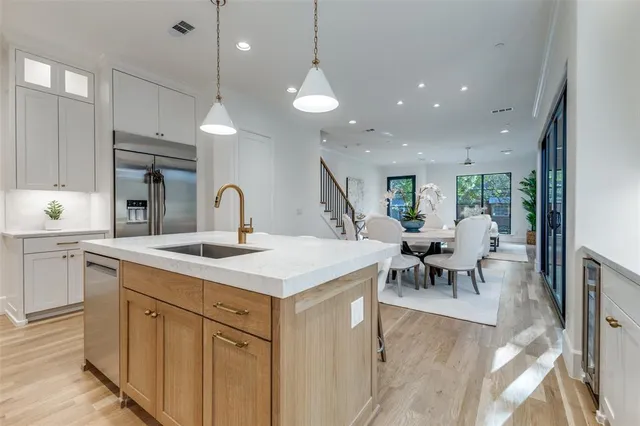 a kitchen with center island a sink stainless steel appliances and dining table