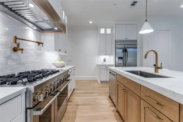 a kitchen with stainless steel appliances a sink stove and cabinets