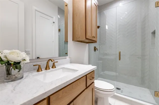 a bathroom with a sink a toilet and shower