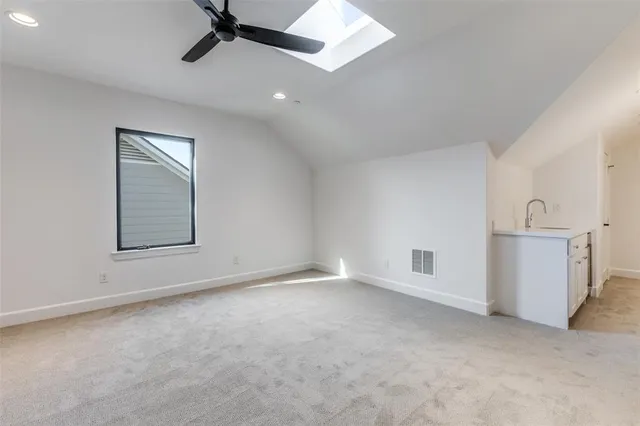 an empty room with a ceiling fan and windows