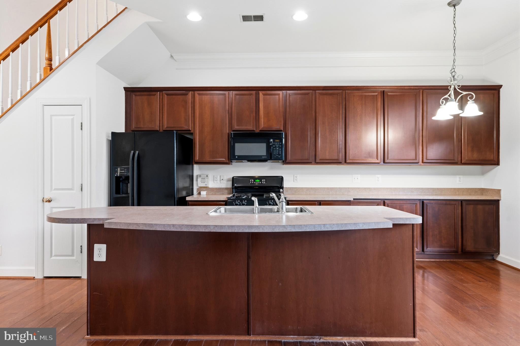 9227 Ribbon Falls Loop Bristow, VA 20136 - Photo 19 of 53 a kitchen with kitchen island granite countertop stainless steel appliances a refrigerator a stove top oven a sink and dishwasher