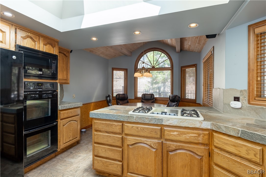 599 Cove Drive Big Bear Lake, CA 92315 - Photo 13 of 50 a kitchen with stainless steel appliances granite countertop a stove a sink and a refrigerator
